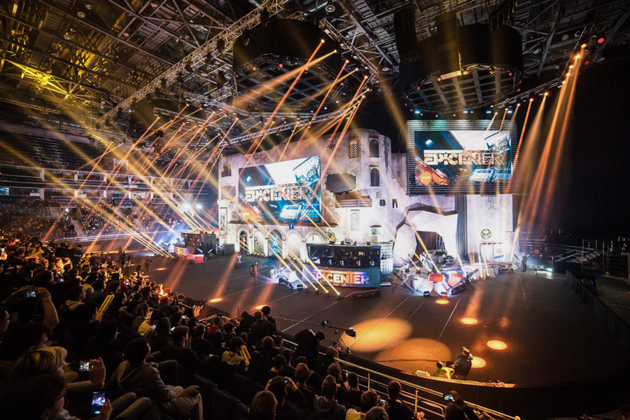 An electrifying esports tournament atmosphere with dynamic stage lighting and large screens, showcasing an intense gaming battle to an engaged crowd.