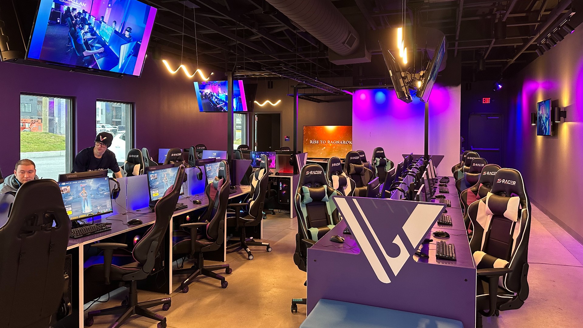 An esports training facility equipped with state-of-the-art gaming setups, ergonomic chairs, and multiple screens displaying live gameplay, providing an ideal environment for developing competitive gaming skills.